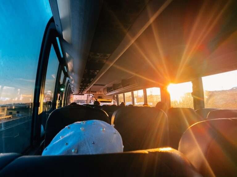 Passengers on a bus with sunlight shining through the window